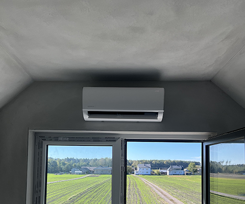 Jednostka wewnętrzna klimatyzacji zamontowana nad oknem w domu pod Krakowem