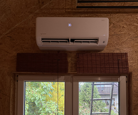 Jednostka wewnętrzna klimatyzatora z wyświetlaczem LED zamontowana nad oknami w Krakowie