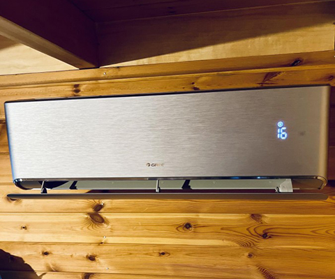 Jednostka wewnętrzna Gree zamontowana na ścianie z drewna w domu w Rzeszowie