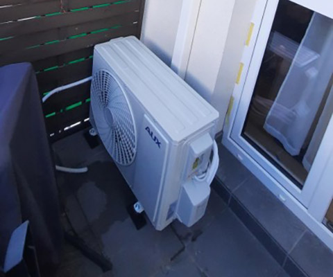 Jednostka zewnętrzna AUX przy elewacji z pionową listwą — Warszawa