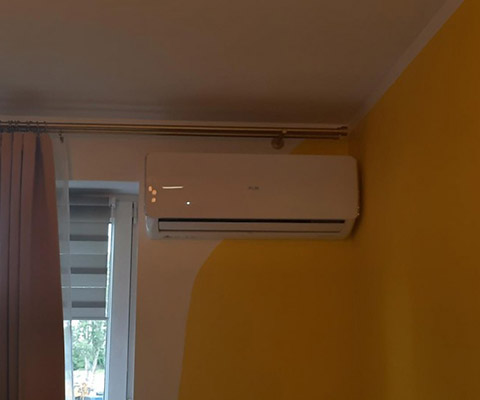 Jednostka wewnętrzna AUX przy oknie — Warszawa, pokój na żółtej ścianie