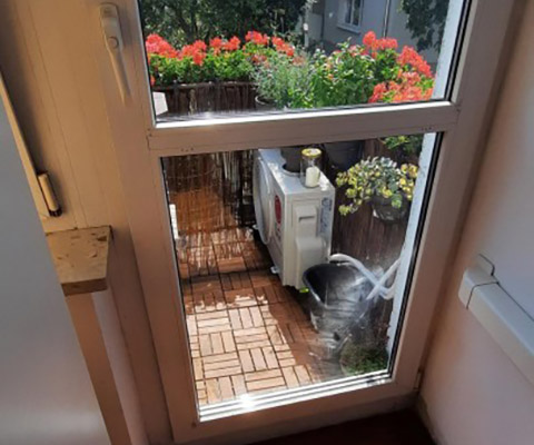 Jednostka zewnętrzna na balkonie wśród roślin — Warszawa