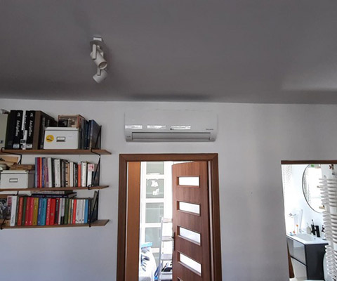 Jednostka wewnętrzna nad drzwiami — Warszawa, pokój z regałami