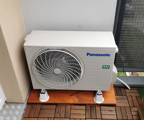 Jednostka zewnętrzna Panasonic zamontowana na balkonie we Wrocławiu, na drewnianej podstawie