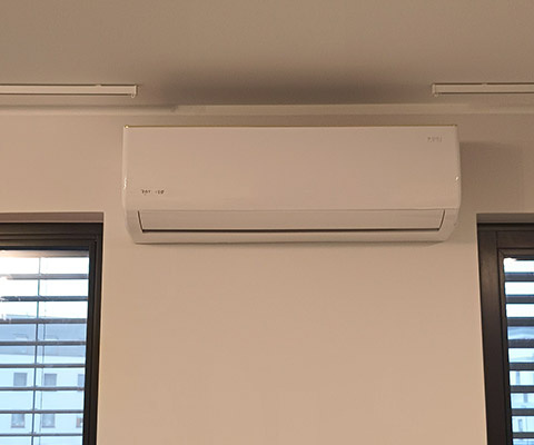 Jednostka wewnętrzna klimatyzatora zamontowana między oknami w Łomży