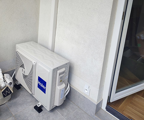 Jednostka zewnętrzna klimatyzatora ustawiona na balkonie w Łomży