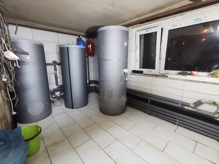 Gotowa kotłownia z dużymi zbiornikami i uporządkowaną instalacją po montażu pompy ciepła