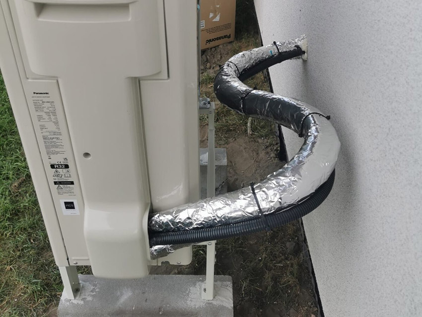 Przejście instalacji przez ścianę oraz zabezpieczone przewody prowadzone do wnętrza budynku